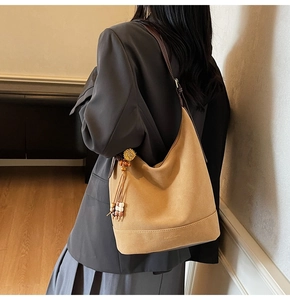 Détail du sac cabas en daim avec pompons de perles artistiques et texture gaufrée