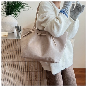 Detail of apricot large suede tote bag featuring decorative drawstring and soft texture