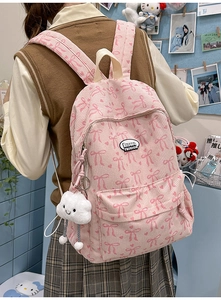 Detailed back view of pink corduroy backpack with bow patterns and cloud plush pendant