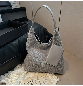 Detailed close-up of grey plush fleece tote bag with matching leather pouch and strap