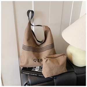 Minimalist khaki canvas tote bag set on art books with matching zipper pouch and QZB logo