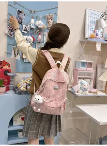 Pink corduroy backpack with bow print and cute cloud pendant shown on a model back