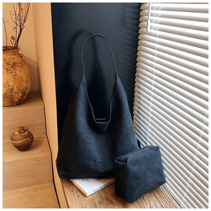 Detail of black canvas tote bag with QZB embroidery on a sunlit wooden windowsill