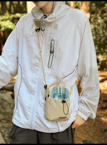 Détail du sac gourde en nylon beige avec doublure bleue et fermeture par cordon de serrage