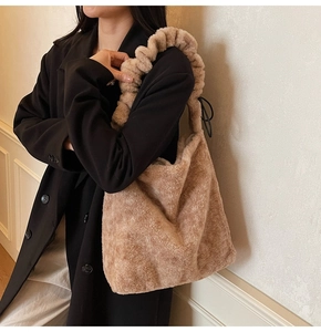Detail of camel plush shoulder bag with trendy ruched handle and soft faux fur texture