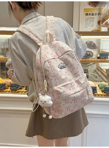 Detail of cream corduroy backpack with pink bow prints and cute plush cloud pendant