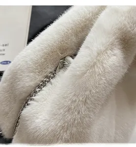 Detail of white fluffy faux fur bucket bag with polished silver metal chain and hook