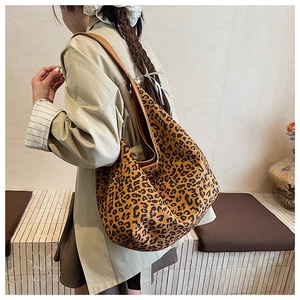 Detail of leopard print tote bag showing large capacity and soft suede texture on a model