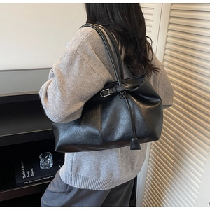 Détail du sac cabas minimaliste en similicuir noir avec boucle métallique et texture souple