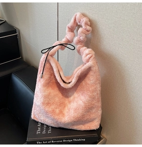 Close-up of pink plush shoulder bag featuring a ruffled strap and black ribbon bow detail
