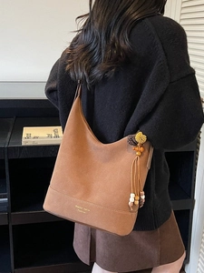 Grand sac seau marron en daim dépoli avec pompon en perles et bandoulière large