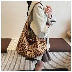 Detailed side view of vintage leopard print tote bag worn on shoulder by model