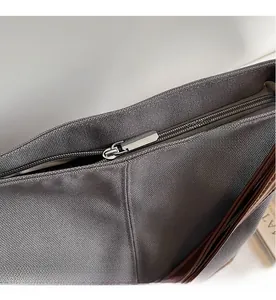 Detail shot of smooth silver metal zipper on durable gray canvas handbag for women