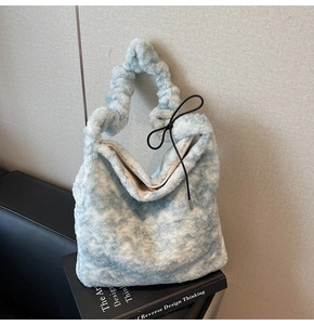 Detail view of light blue plush handbag with soft faux fur and ruched cloud handle