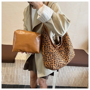 Detail of leopard print tote bag and small leather pouch set with textured finish