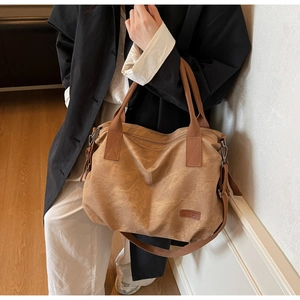 Brown vintage tote bag detail showing the oily leather texture and adjustable shoulder strap