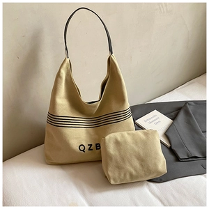 Detail of canvas tote bag with matching inner pouch on white surface with blazer