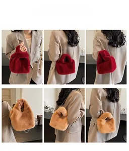 Detail view of plush faux fur bucket bags in deep red and khaki with metal chain straps