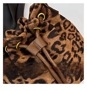Gros plan sur le sac seau léopard avec cordon de serrage et détails en cuir premium