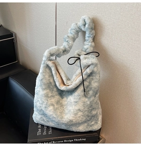 Detailed view of light blue plush handbag featuring faux fur and ruched cloud handle