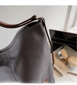 Close-up of durable dark grey canvas tote bag with premium brown leather straps for work