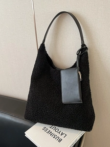 Vintage black fuzzy fleece tote bag with a small coin purse on a leather sofa