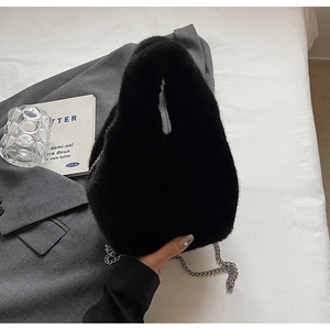 Close-up of black faux fur bucket bag featuring a sleek silver metal chain strap