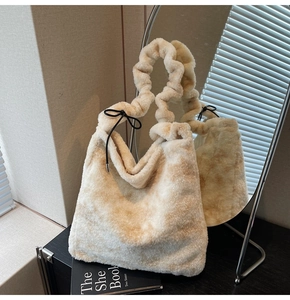 Detail of plush beige faux fur handbag featuring a scrunchie handle and black bow knot