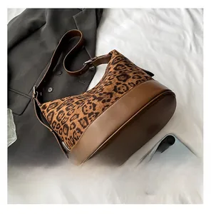 Dettaglio della borsa a secchiello leopardata con finiture in pelle marrone e fibbia argento