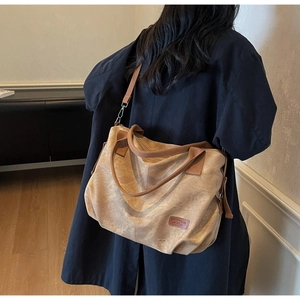 Detailed view of khaki large capacity tote bag with brown straps and brand label