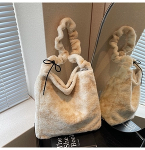 Detail view of plush faux fur tote bag with scrunchie strap and black bow decoration
