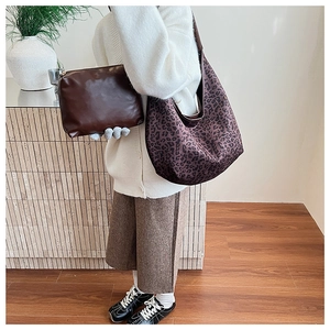 Fashionable purple leopard print tote bag with small brown leather clutch shown on model