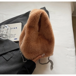 Close-up of brown faux fur bucket bag with silver metal chain strap for winter fashion