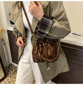 Gros plan du sac seau à imprimé léopard avec poignées en cuir et cordon de serrage