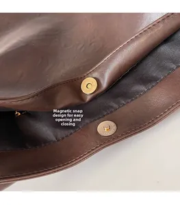 Detail view of the magnetic buckle closure on a large capacity dark brown tote bag