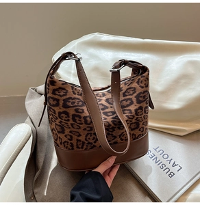 Dettaglio dei cinturini in pelle marrone regolabili e fibbie argentate della borsa leopardata