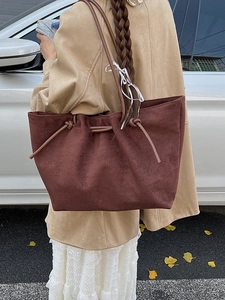 Large dark brown suede tote bag for women with shoulder straps in an outdoor setting