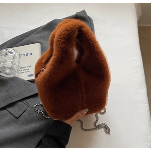 Detailed macro view of caramel brown faux fur bucket bag with silver metal chain strap