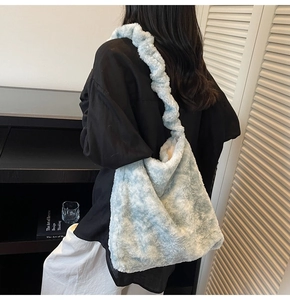 Detail of light blue faux fur shoulder bag with ruched strap on model