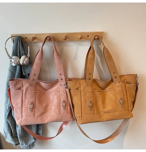 Detail view of pink and yellow large tote bags with matte finish and metal ring decor