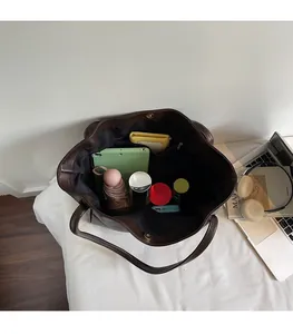 Top-down view of large brown tote bag interior with tablet, umbrella, and accessories