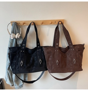 Detail of minimalist faux leather tote bags in black and brown with rivet accents