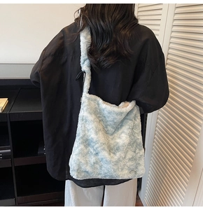 Detail of light blue faux fur shoulder bag with adjustable strap and soft plush texture