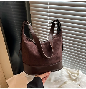 Dettaglio della texture in pelle scamosciata marrone e pelle liscia della borsa a tracolla