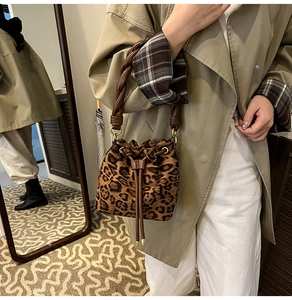 Détail du sac seau imprimé léopard avec fermeture à cordon et poignées marron torsadées