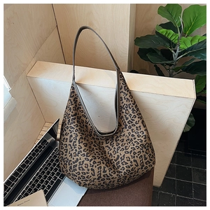 Detail view of large leopard print hobo bag with sleek shoulder strap on a display stand