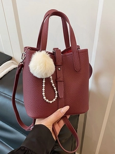 Borsa a secchiello bordeaux in pelle con ciondolo in peluche e catena di perle chic