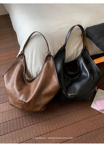 Detail view of vintage oil wax leather tote bags in dark brown and black finishes