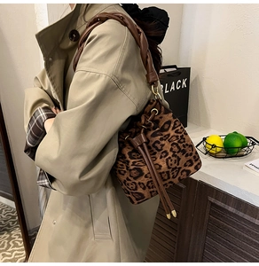 Détail du sac seau à motif léopard avec poignée tissée marron et fermeture à cordon