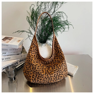Detailed close-up of leopard print hobo bag on desk with elegant lifestyle accessories